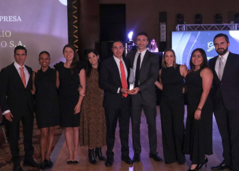 Equipo de Portafolio Inmobiliario posando en una ceremonia de premiación, donde reciben un reconocimiento. Los miembros del equipo están vestidos de manera formal y se muestran sonrientes y unidos, sosteniendo el trofeo que simboliza su logro